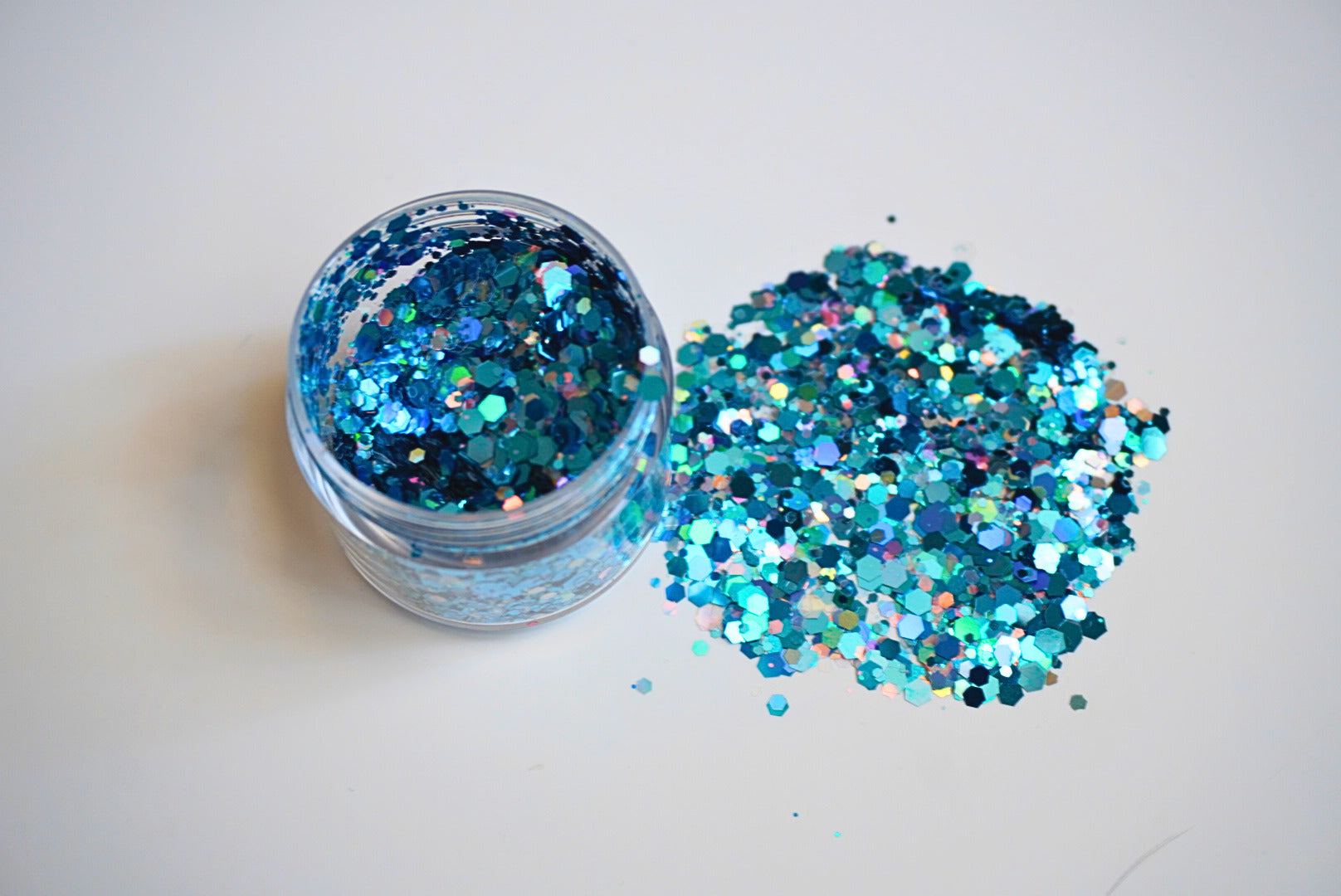 Icy Girl teal and blue chunky glitter mix spilling from a jar